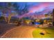 Backyard view featuring patio furniture near a pool, xeriscaping, and a wrought iron fence at dusk at 22847 N 53Rd E St, Phoenix, AZ 85054