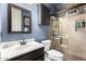 Bathroom featuring a dark wood vanity, a white sink, a tiled shower with a glass door, and blue walls at 22847 N 53Rd E St, Phoenix, AZ 85054