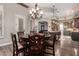 Open-concept dining room with dark wood floors, a chandelier, and a seamless transition to the kitchen and living areas at 22847 N 53Rd E St, Phoenix, AZ 85054