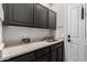 Functional laundry room with gray cabinets, laminate countertops and a stainless-steel sink at 22847 N 53Rd E St, Phoenix, AZ 85054