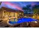 Custom pool with rock surround and bright LED lighting, reflecting the home's exterior at 22847 N 53Rd E St, Phoenix, AZ 85054
