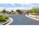 Community entrance featuring decorative metal gate, landscaped surroundings, and well-maintained asphalt road at 24226 N 22Nd St, Phoenix, AZ 85024