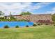 Community pool featuring a stone wall with the neighborhood name and a lush green lawn at 24226 N 22Nd St, Phoenix, AZ 85024