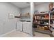 Laundry room with modern appliances, storage shelves, and tile floors at 24226 N 22Nd St, Phoenix, AZ 85024