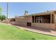 A covered porch is shaded and looks onto a gravel and grassy lawn at 25230 S Berry Brook Dr, Sun Lakes, AZ 85248