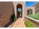 Inviting home entryway featuring a decorative archway and well-maintained landscaping at 25230 S Berry Brook Dr, Sun Lakes, AZ 85248
