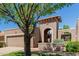 Inviting beige home featuring an arched entrance, red tile roof, and mature landscaping with trees at 25230 S Berry Brook Dr, Sun Lakes, AZ 85248
