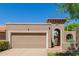 Beige home featuring an arched entrance and two car garage at 25230 S Berry Brook Dr, Sun Lakes, AZ 85248