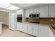 Bright kitchen with white cabinetry, stainless steel microwave and granite countertops at 25230 S Berry Brook Dr, Sun Lakes, AZ 85248