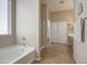 Bright bathroom features a soaking tub, separate shower, and neutral tile flooring at 25659 W Forest Grove Ave, Buckeye, AZ 85326