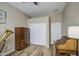 Cozy bedroom featuring a wood-look laminate floor, a ceiling fan, and an eclectic set of furnishings at 25659 W Forest Grove Ave, Buckeye, AZ 85326