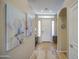 Welcoming foyer with tile flooring, neutral paint, and decoratively framed floral paintings on the wall at 25659 W Forest Grove Ave, Buckeye, AZ 85326