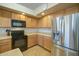Well-lit kitchen featuring stainless steel refrigerator and dark appliances at 25659 W Forest Grove Ave, Buckeye, AZ 85326