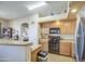 Bright kitchen features a breakfast bar, modern appliances, and easy access to adjacent room at 25659 W Forest Grove Ave, Buckeye, AZ 85326