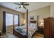 Cozy main bedroom with ceiling fan, wooden floors, and a comfortable four-poster bed at 25659 W Forest Grove Ave, Buckeye, AZ 85326