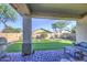 Inviting covered patio features brick pavers and overlooks the lush, low-maintenance artificial turf backyard at 25659 W Forest Grove Ave, Buckeye, AZ 85326