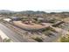 Aerial view of the desert property featuring the custom home, large garage, desert landscaping, and stone perimeter wall at 28758 N Ashbrook Ln, San Tan Valley, AZ 85144