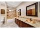Bathroom with granite countertops, dual copper sinks, tiled shower/bath and wood cabinetry at 28758 N Ashbrook Ln, San Tan Valley, AZ 85144