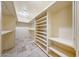 Walk-in closet boasting white shelving and travertine tile flooring at 28758 N Ashbrook Ln, San Tan Valley, AZ 85144