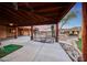 Large covered patio overlooks a green with a net, and lush landscaping with a waterfall feature at 28758 N Ashbrook Ln, San Tan Valley, AZ 85144