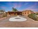 Desert home featuring a spacious driveway with concrete design and native landscaping under twilight sky at 28758 N Ashbrook Ln, San Tan Valley, AZ 85144
