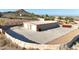 Elevated view of a detached garage with multiple bays, large parking area, and secure stone wall at 28758 N Ashbrook Ln, San Tan Valley, AZ 85144