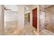 Hallway showcasing the travertine floors, closet, and a tiled walk-in shower at 28758 N Ashbrook Ln, San Tan Valley, AZ 85144