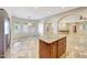 Kitchen island features wood cabinetry, granite countertops, and travertine tile flooring at 28758 N Ashbrook Ln, San Tan Valley, AZ 85144