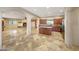 Open-concept kitchen and living room area with fireplace and travertine tile flooring at 28758 N Ashbrook Ln, San Tan Valley, AZ 85144