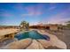 Beautiful backyard pool features stone border, water fall, and desert landscaping at 28758 N Ashbrook Ln, San Tan Valley, AZ 85144