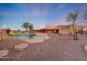 Unique backyard oasis with lagoon-style pool, desert landscaping, and a charming home exterior at 28758 N Ashbrook Ln, San Tan Valley, AZ 85144