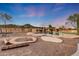 Amazing backyard pool with waterfall feature, fire pit, and desert landscaping creates an entertainer's dream at 28758 N Ashbrook Ln, San Tan Valley, AZ 85144