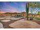 The backyard has a stunning pool with a waterfall feature, complemented by lush desert landscaping and a cozy putting green at 28758 N Ashbrook Ln, San Tan Valley, AZ 85144
