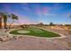 Custom putting green features artificial turf and sand trap, surrounded by desert landscaping at 28758 N Ashbrook Ln, San Tan Valley, AZ 85144