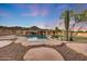 Relax by the custom pool with a waterfall, desert plants, and putting green, creating a serene outdoor retreat at 28758 N Ashbrook Ln, San Tan Valley, AZ 85144