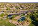 Neighborhood park with a playground, basketball court, and shade structures surrounded by lush greenery at 3055 N Red Mtn # 122, Mesa, AZ 85207