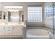 Bright bathroom with a soaking tub, double sinks, and decorative glass block window at 3055 N Red Mtn # 122, Mesa, AZ 85207