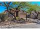 Tan single-story home with desert landscaping, and a large shade tree in the front yard at 3055 N Red Mtn # 122, Mesa, AZ 85207