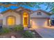 Beautiful home featuring manicured desert landscaping, a two-car garage, and warm exterior lighting at 3055 N Red Mtn # 122, Mesa, AZ 85207