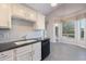 Open kitchen area featuring white cabinets, dark countertops, and an adjacent dining area with backyard views at 3055 N Red Mtn # 122, Mesa, AZ 85207