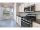 Contemporary kitchen with white cabinets, stainless steel appliances, and a dining area with backyard views at 3055 N Red Mtn # 122, Mesa, AZ 85207