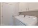 Clean laundry room featuring washer, dryer, white cabinets, and outdoor access at 3055 N Red Mtn # 122, Mesa, AZ 85207