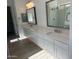 Luxurious bathroom featuring double sinks, sleek white cabinets, and modern fixtures and a glass-enclosed shower at 3637 E Rochelle Cir, Mesa, AZ 85213