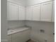Laundry room featuring bright white cabinets, a marble countertop and backsplash, plus sink at 3637 E Rochelle Cir, Mesa, AZ 85213
