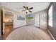 Bedroom featuring a ceiling fan, mounted TV, neutral walls, and hardwood floors with carpeted area at 41143 W Rio Bravo Dr, Maricopa, AZ 85138
