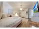Bright bedroom with white walls, plush bedding, a TV, and hardwood floors with a cream carpet at 41143 W Rio Bravo Dr, Maricopa, AZ 85138