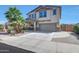 Two-story home boasts a neutral color palette, palm trees, large driveway, and attached two-car garage at 41143 W Rio Bravo Dr, Maricopa, AZ 85138