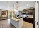 Modern kitchen features pendant lighting, an island with granite countertops, and dark wood cabinetry at 41143 W Rio Bravo Dr, Maricopa, AZ 85138