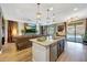 Open-concept kitchen with granite island, pendant lights, and stainless steel appliances, flowing into living space at 41143 W Rio Bravo Dr, Maricopa, AZ 85138