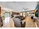 Open-concept living room featuring a large sofa and flowing seamlessly into the kitchen area at 41143 W Rio Bravo Dr, Maricopa, AZ 85138